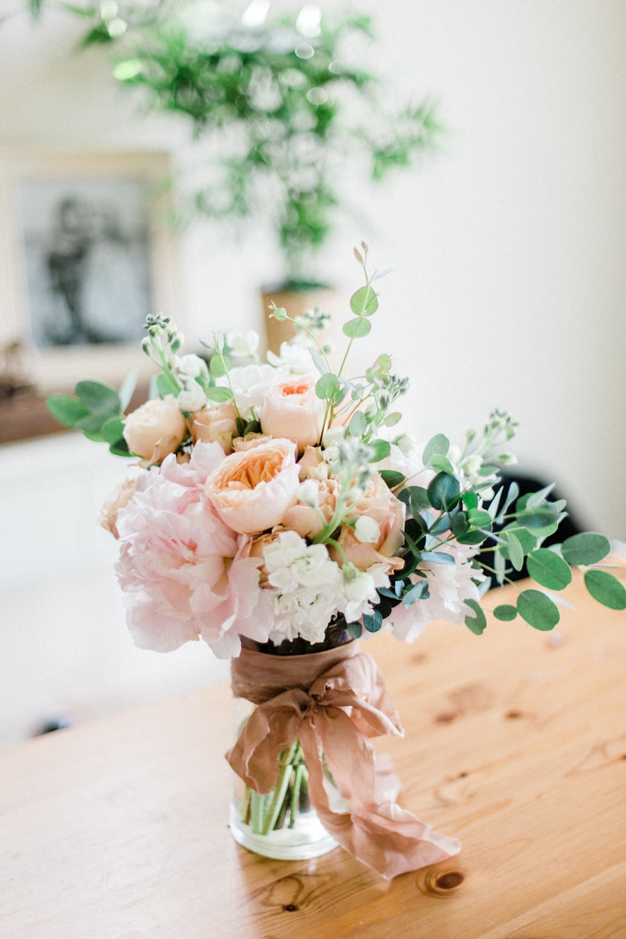 Peach and blush posy in a glass vase tied with a brown ribbon